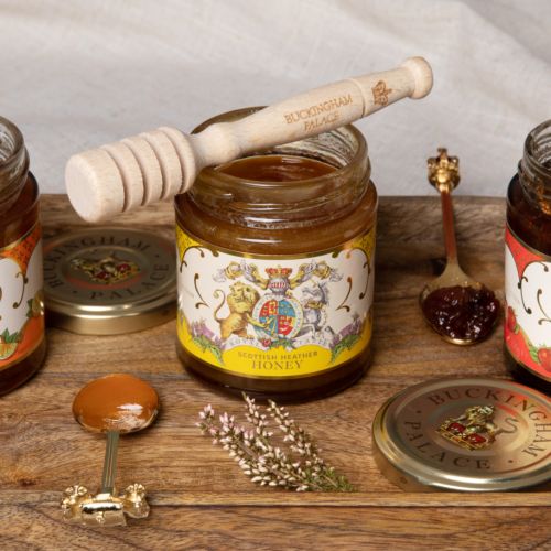 Glass jar of honey with yellow and cream label featuring the coat of arms