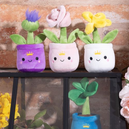 Plush white pot with a smiley face and crown, with a yellow daffodil. 