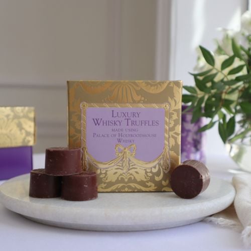 A golden patterned box with with a puple centre, with "Luxury Whisky Truffles, made using Palace of Holyroodhouse Whisky" text at centre in dark purple. 