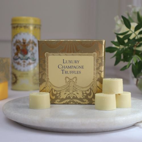 A golden patterned box with light yellow centre, featuring "Luxury Champagne Truffles" written in centre in blue text. 