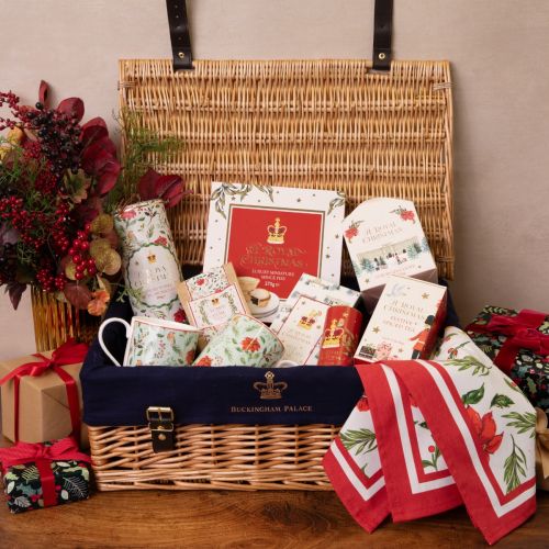 Wicker hamper with two festive mugs, two tubes of biscuits, mince pies, tea, chocolate bar, chocolate lumps of coal, a box of truffles and 2 festive napkins.
