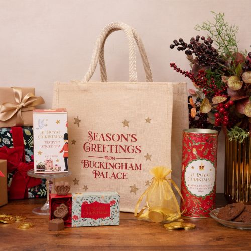 jute bag with seasons greetings from buckingham palace written on the front in red. range of the contents around the bag with presents and flowers