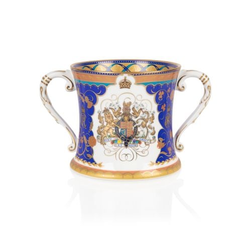 Fine bone china loving cup with blue and gold design, coat of arms at the centre on a white background. Gold band and blue ribbon inside the lip of the cup