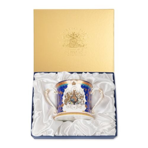 Fine bone china loving cup with blue and gold design, coat of arms at the centre on a white background. Gold band and blue ribbon inside the lip of the cup