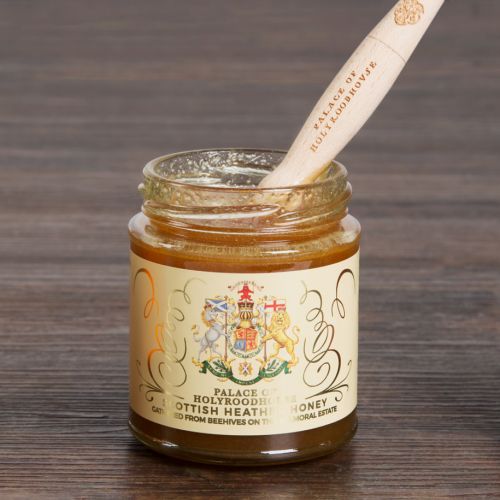 Glass jar of honey with gold lid. The jar is wrapped with a label displaying the Scottish Coat of Arms.