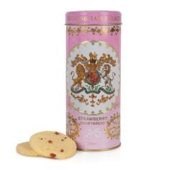 pink biscuit tin with the crest at the centre of the tin. Stood next to a few biscuits