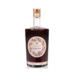 50 cl bottle of sloe gin. A clear glass bottle with a gold circular design on the front surrounded by sloe berries and other greenery 