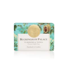 bar of soap wrapped in blue paper printed with tuberose and tonka beans. There is also a gold seal with a crown and a white box saying 'Buckingham Palace Tuberose and Tonka Premium English Soap Handmade in London'