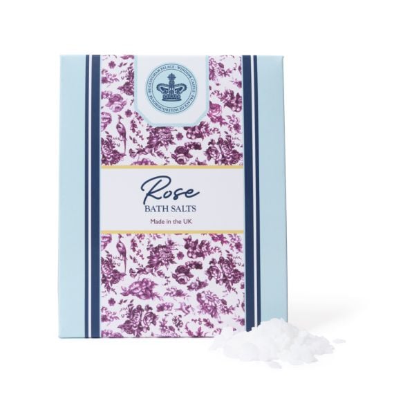 Rose bath salts presented in an elegant pale blue box with a central floral panel in deep pink and a crowned crest motif, accompanied by loose bath salts.
