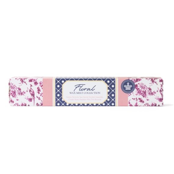Long rectangular box of floral wax melts with pink and navy patterned packaging, featuring a central label that reads “Floral Wax Melt Collection” and lists scents including Serenity Spa, Secret Garden, Lavender, Cinder Rose, Heather Mist, and The Botanis
