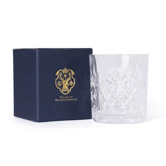 Clear cut-glass tumbler engraved with the Palace of Holyroodhouse crest, shown beside a navy box with gold crest and text.