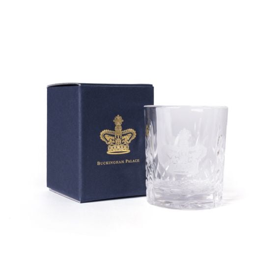 Clear cut-glass tumbler engraved with the Buckingham Palace Crown, shown beside a navy box with gold crest and text