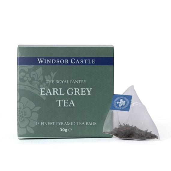 Box of Earl Grey Tea from The Royal Pantry, Windsor Castle range, presented in a sage green carton with navy detailing and a floral pattern. The box contains 15 finest pyramid tea bags, with a single pyramid tea bag filled with loose tea leaves displayed 