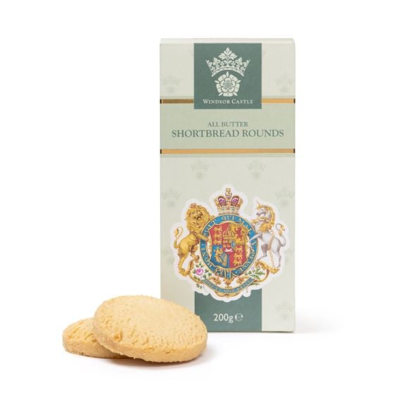 Box of Windsor Castle all butter shortbread rounds with two biscuits placed in front, featuring a royal coat of arms design, 200g.
