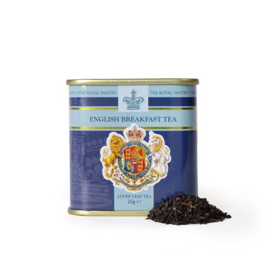 Tin of English Breakfast Tea from The Royal Pantry, featuring a navy blue and pale blue design with the Royal Coat of Arms and crown motif. The gold-lidded tin contains 25g of loose leaf tea, with a small pile of dark tea leaves displayed beside it.