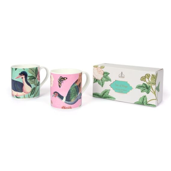 Pair of bone china mugs depicting scenes from the East Wing of Buckingham Palace, next to presentation box.