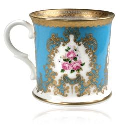 Royal coat of arms fine bone china tankard featuring a lion and unicorn royal crest surrounded by ornated gold patterns and flower patterns on a light blue coloured background. Gold plated with the words Buckingham Palace, Windsor Castle and Palace of Hol
