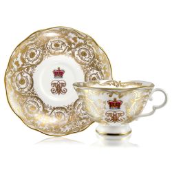 Victoria and Albert teacup and saucer featuring the ciphers of Queen Victoria and Prince Albert surmounted by a royal crown and surrounded by intricately ornated gold patterns and gilded rims.