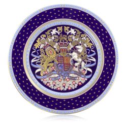 A dinner plate with the lion and unicorn crest at the centre of the plate. Surrounding the crest is a purple, gold and light blue design