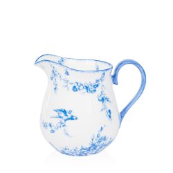 A white cream jug with blue floral garland and bird design.
