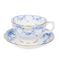 a white teacup and saucer decorated with a blue floral garland and bird design. Finished with 22 carat gold rim