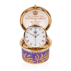 Open pillbox clock with the words 'To celebrate the Platinum Jubilee of Her Majesty The Queen' on the inside of the lid. A purple and gold pattern features on the base