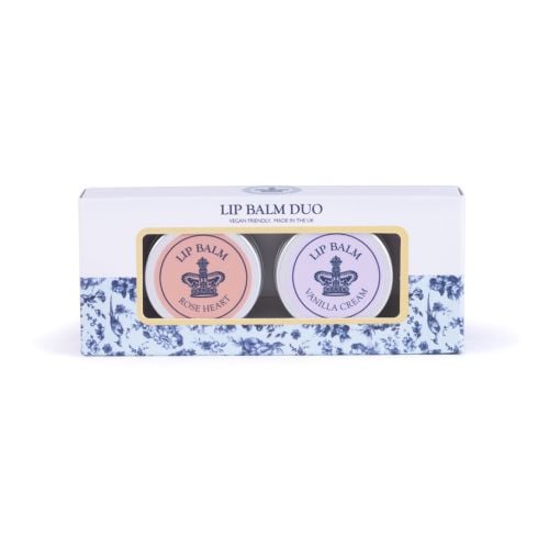 Two lip balm tins with silver lids and crown design, labelled Vanilla Cream (lilac) and Rose Heart (peach), displayed on a light background.