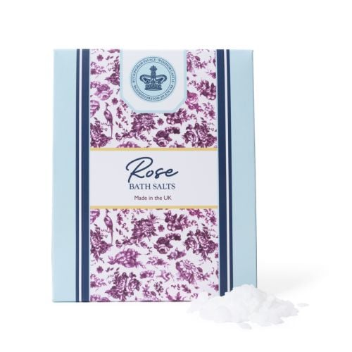 Rose bath salts presented in an elegant pale blue box with a central floral panel in deep pink and a crowned crest motif, accompanied by loose bath salts.
