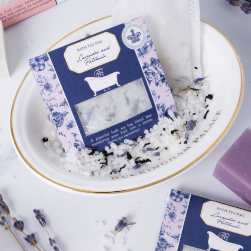 Five boxed bath tea bag products arranged in a staggered layout on a light background, each with decorative floral packaging in different colour schemes (burgundy, blue, pink, and white) and a small window showing the bath tea bags inside.