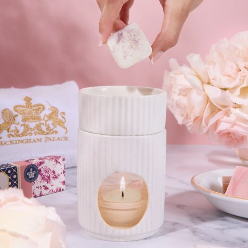 Long rectangular box of floral wax melts with pink and navy patterned packaging, featuring a central label that reads “Floral Wax Melt Collection” and lists scents including Serenity Spa, Secret Garden, Lavender, Cinder Rose, Heather Mist, and The Botanis